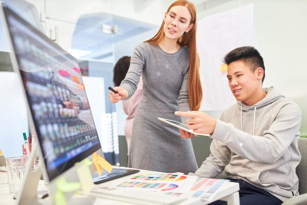 Programmierer und Frau als Webentwickler am PC