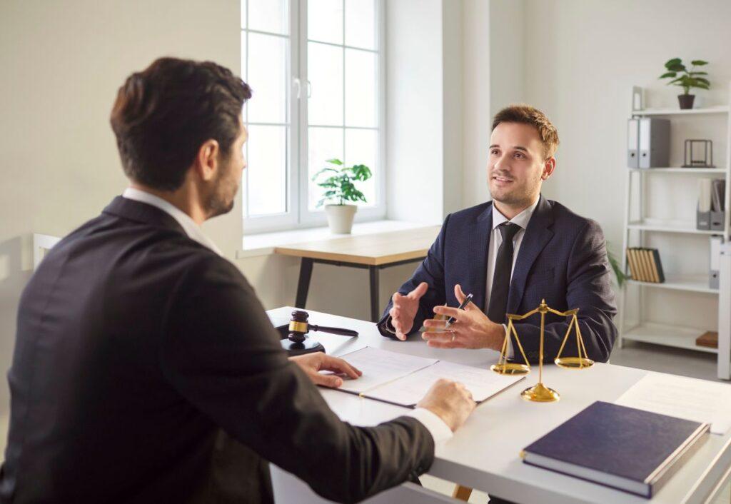 юрист объясняет клиенту статью закона, сидя за столом