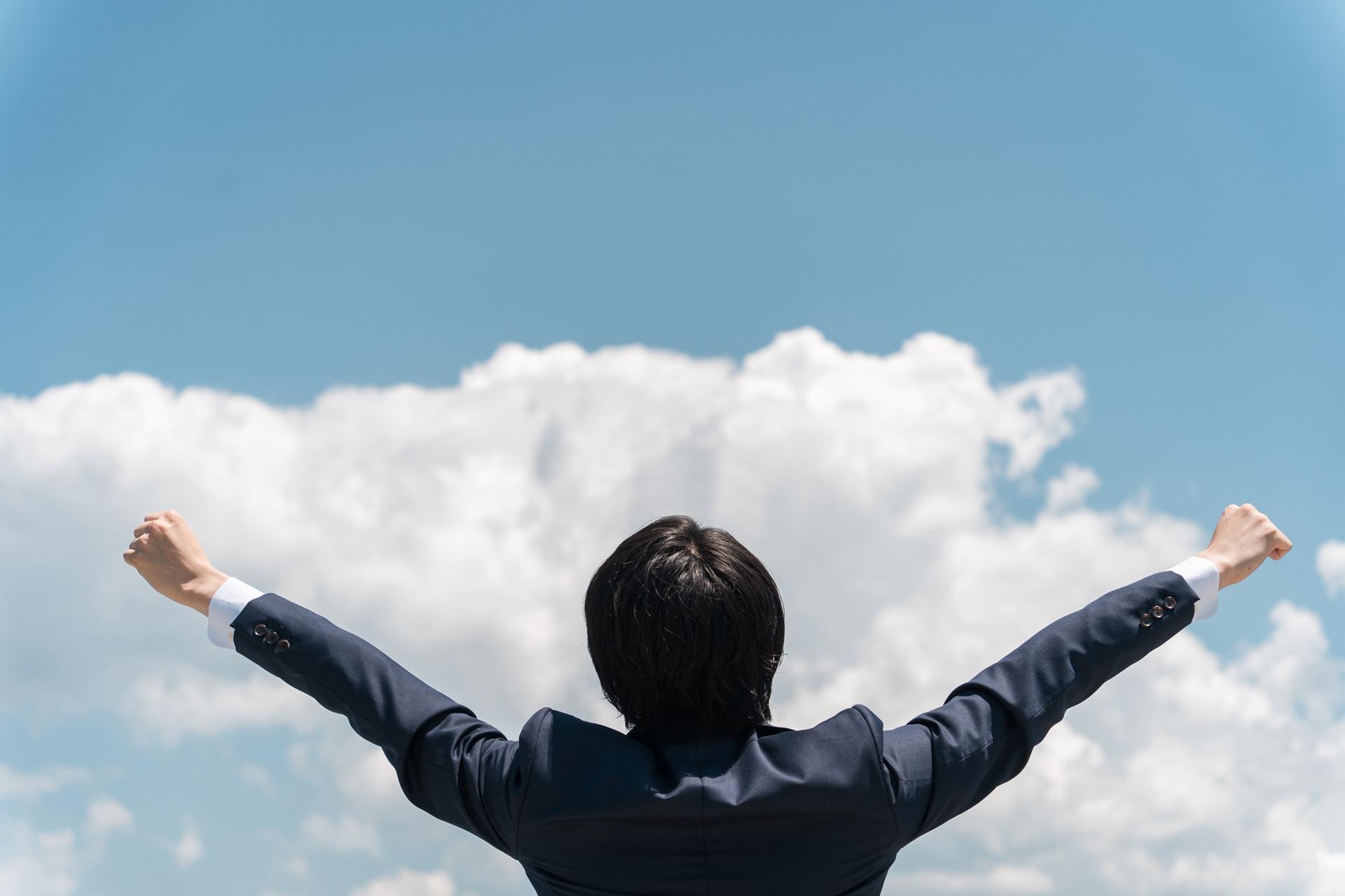 Mann streckt Arme in den Himmel | Weidepanel

