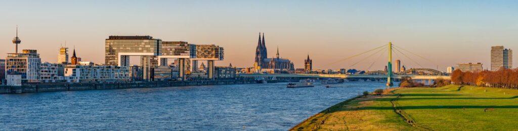 Panorama von Koeln mit Dom, Rhein und Kranhaeusern bei Sonnenuntergang – attraktive Lage fuer Radiologie Köln mit guter Erreichbarkeit.