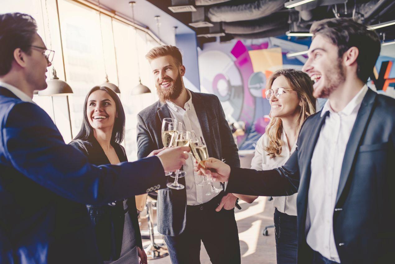 Junge Menschen stossen mit Sekt an bei einem Networking-Event – kreative Eventlocations NRW fuer informelle Veranstaltungen