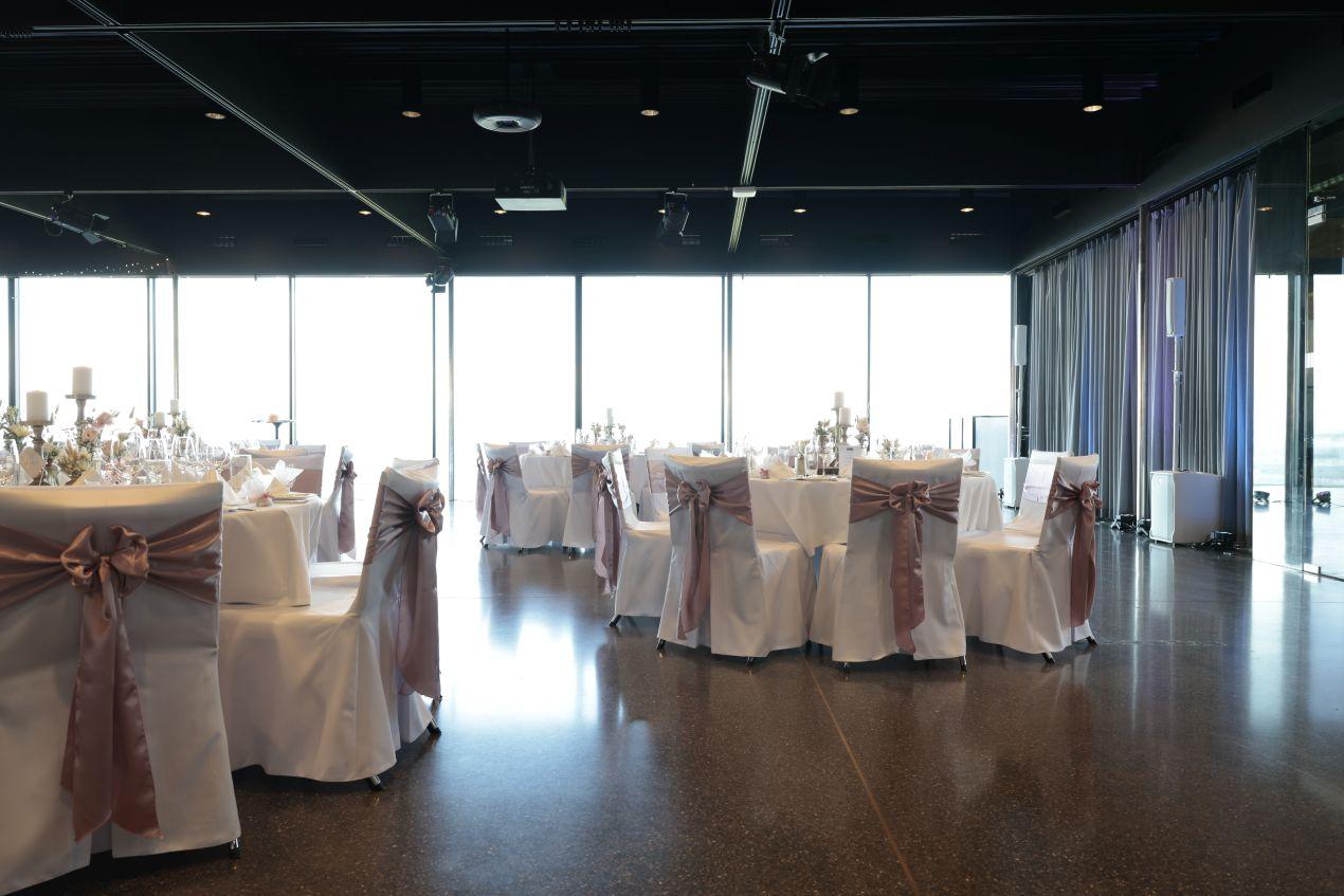 Festlich gedeckter Saal mit weissen Stuehlen und Schleifen – Eventlocations NRW fuer Hochzeiten und Galaevents
